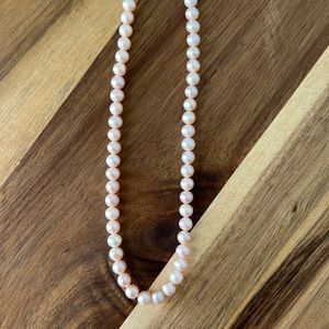 Light pink fresh water pearls. Gold clasp at the top.